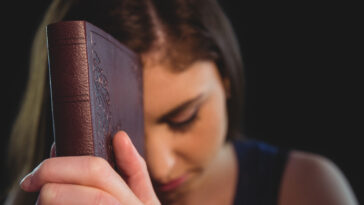 woman praying with her Bible